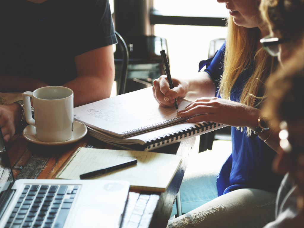 Group of people having a meeting with woman taking notes