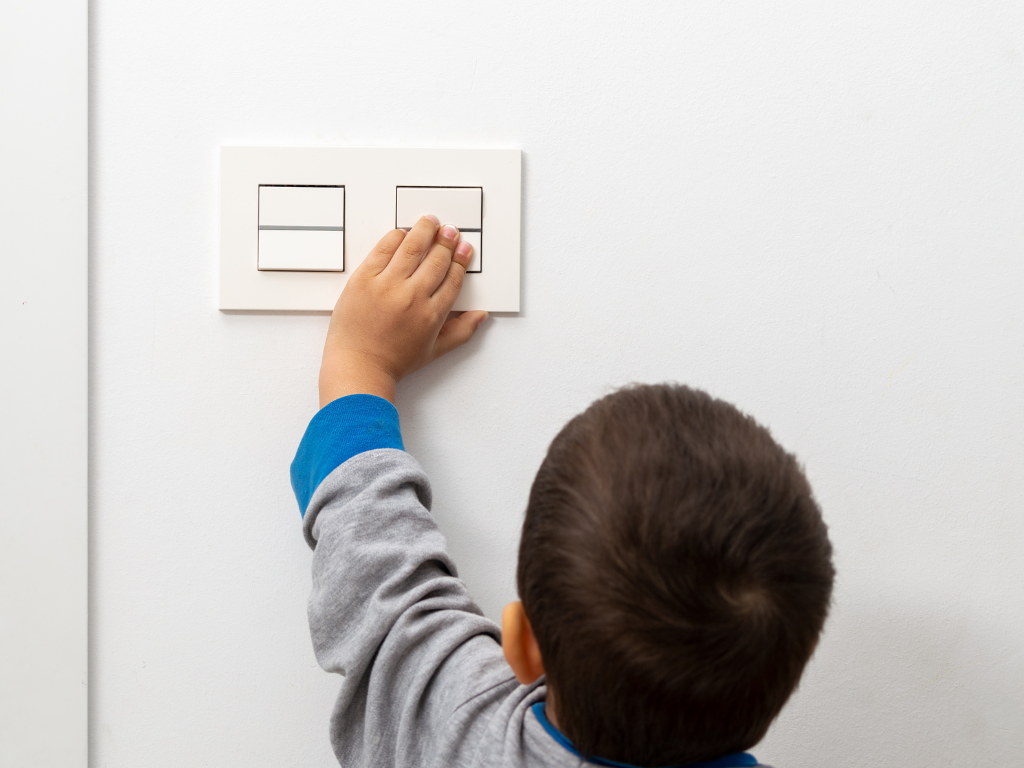 Child turning off a light switch